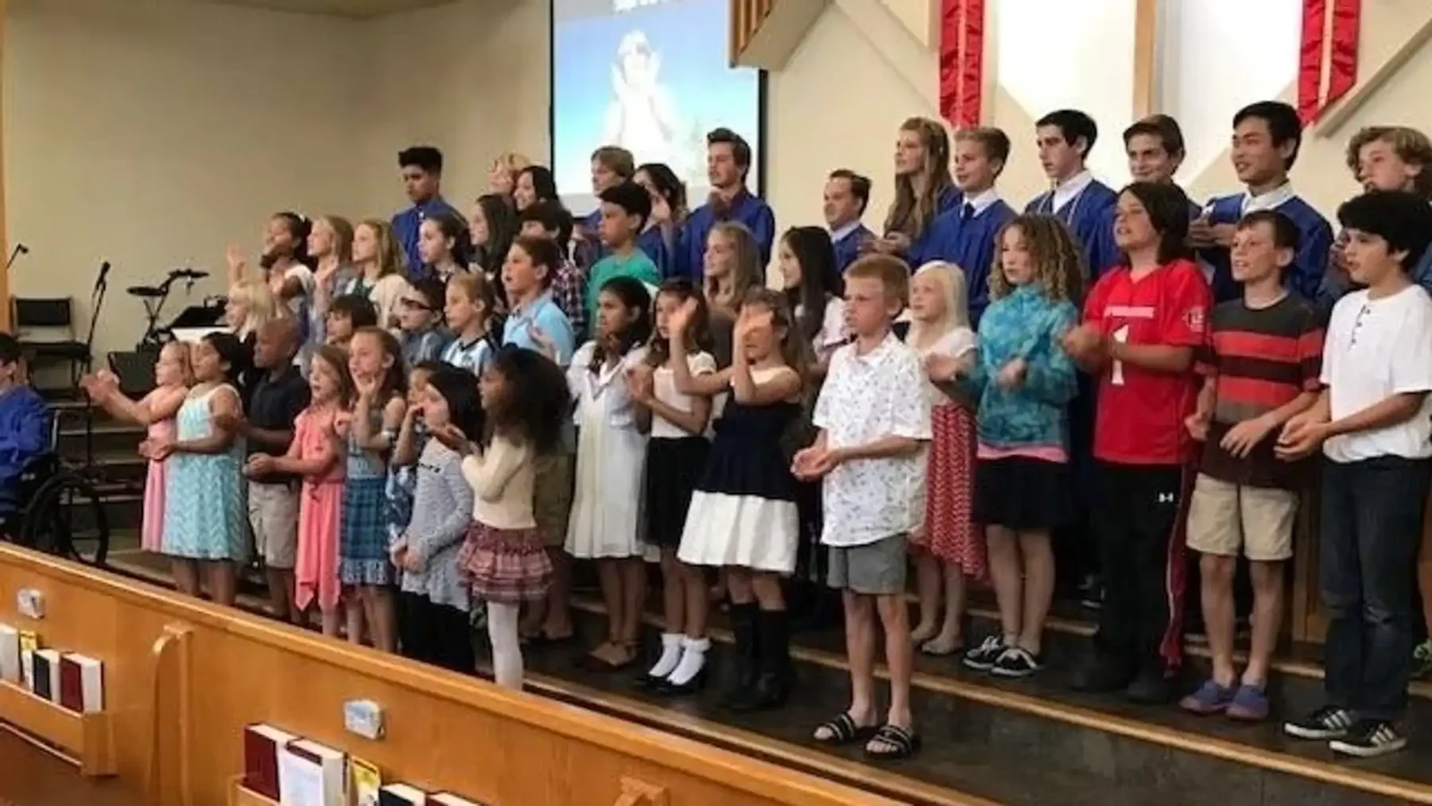 Reformation students singing as a choir in the church sanctuary