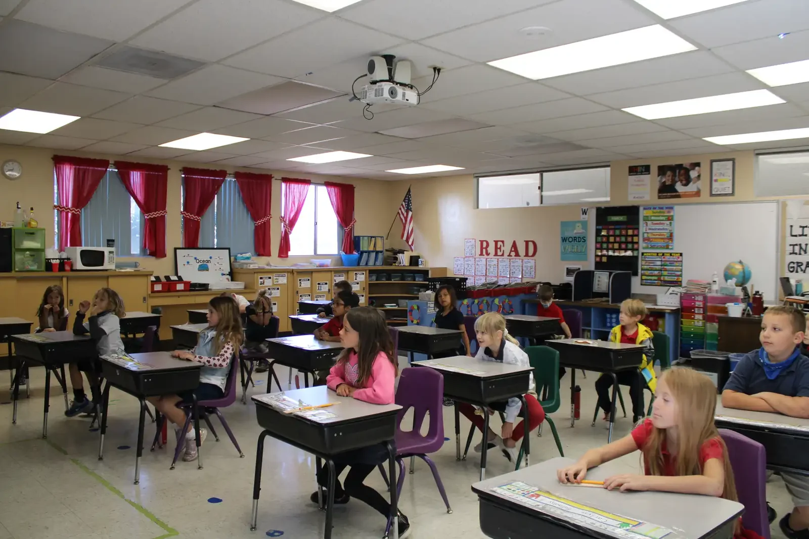 An elementary classroom at Reformation with students at their desks under a READ banner