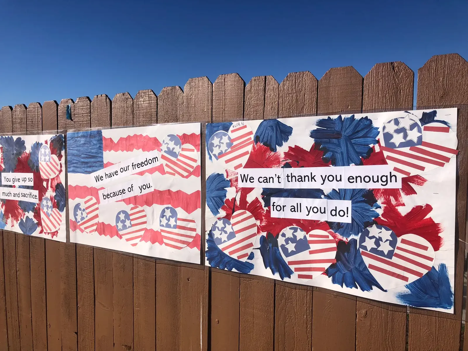 Student-made flag banners reading We can't thank you enough for all you do, hung for Veterans Day
