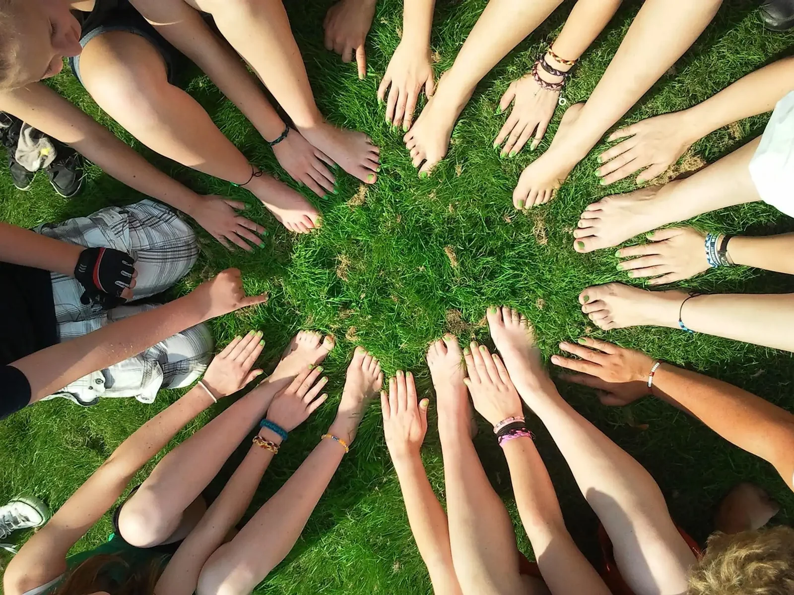 Reformation students' hands joined in a circle on the grass