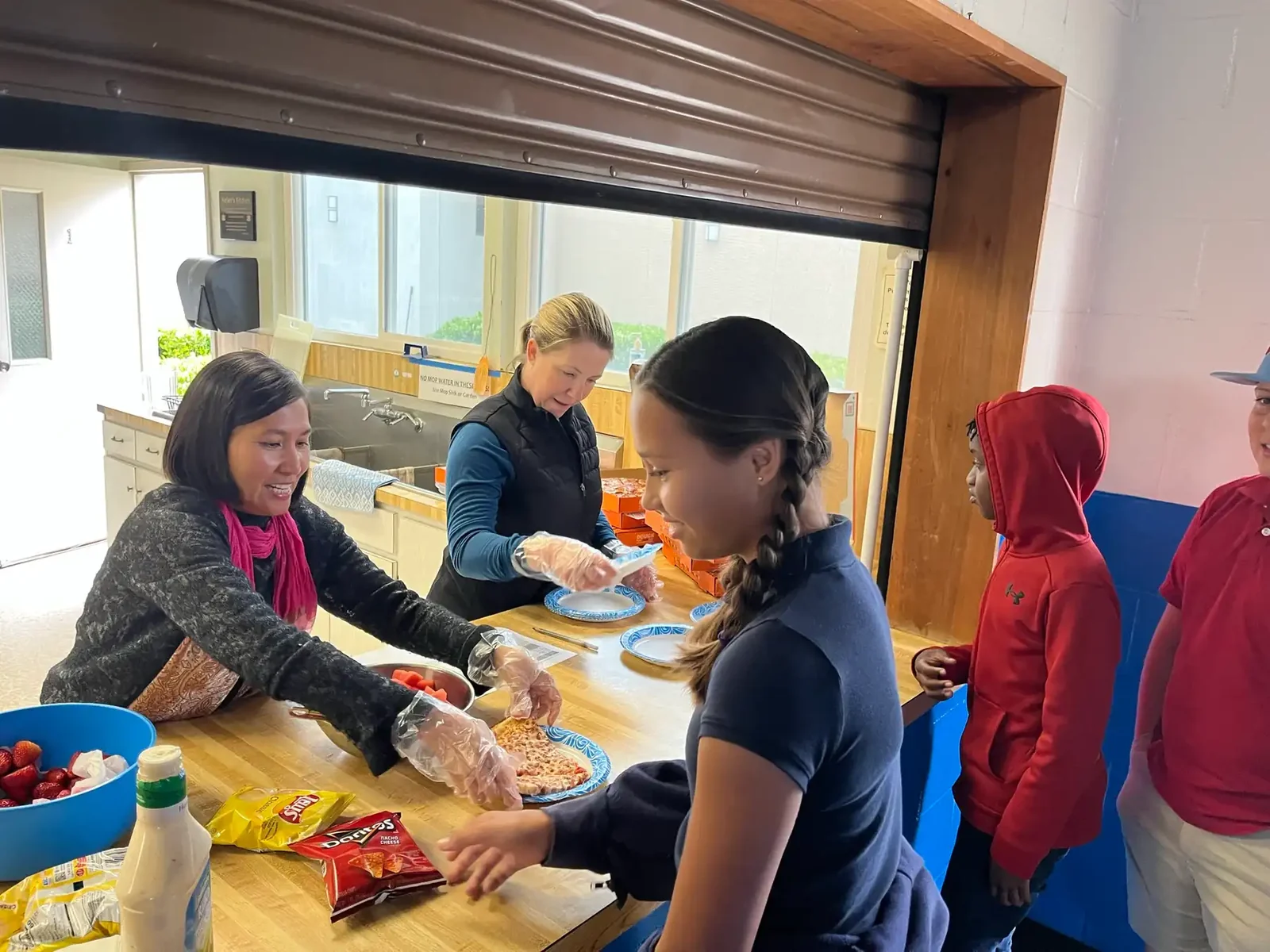 Parent volunteers serving hot lunch to Reformation students