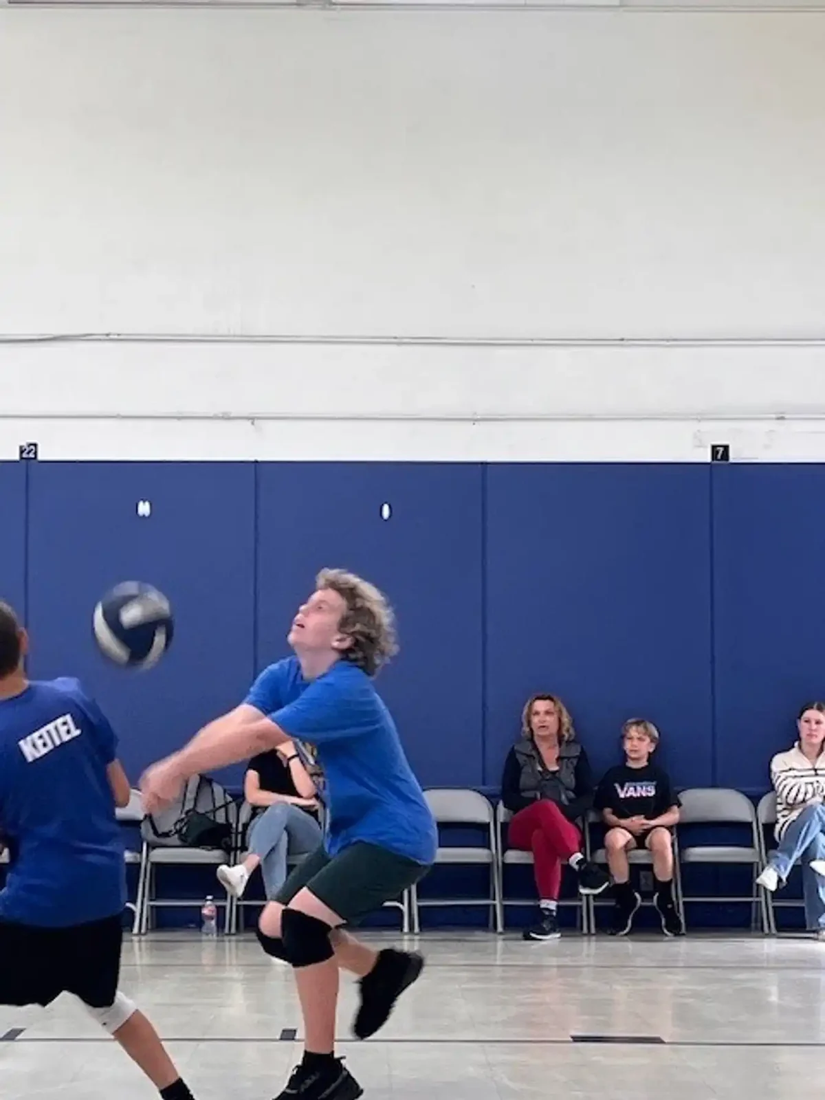 A Reformation student serving during a volleyball match in the gym